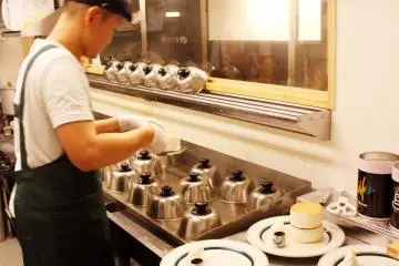 Pancakes are being baked under special metal covers