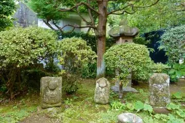 Old stone statues are scattered around the temple grounds