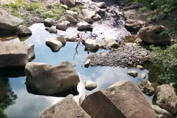 Gray stones contrast the blue reflected in the water