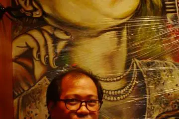 At a bar, a friend poses before a screaming wall