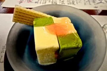 <p>ไอศกรีมกับเมนูที่เขียนด้วยลายมืออยู่ข้างหลัง</p>