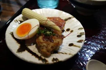 Meal served with half boiled egg and grilled chicken