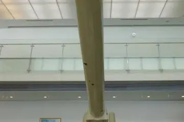 A large cannon stands tall in the museum lobby.
