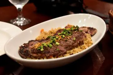 Fried garlic rice with beef steak on top