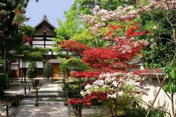 A smaller building on the temple grounds, surrounded by flowers.
