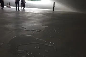 Through a complex system of holes, these water puddles move across the concrete as if propelled through magic