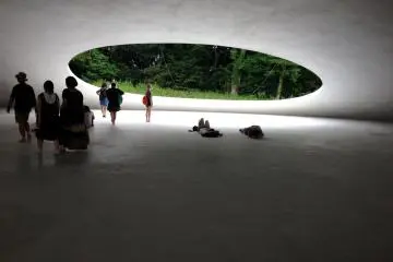 Artist Rei Naito and architect Ryue Nishizawa created the museum to create a connection between nature and architecture. Ovular openings in this ovular building allow wind, sound, and light to enter the organic space. 