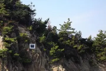 <p>Bring your opera-glasses: I couldn't get close enough to see what was on this screen mounted in the rock by the sea</p>