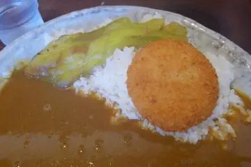 Curry & rice topped with eggplant and a creamy, crab croquette