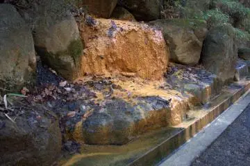 Onsen water, rich with oxidized iron, trickles into the street