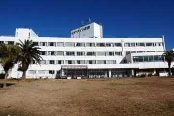 A large lawn sits between the hotel and the sea