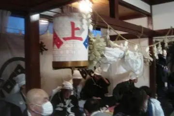 The men of the house where this year's performance takes place are in the back of the room; in front is a lantern with the symbol of the Kami-za, one of Kurokawa's two Noh troupes