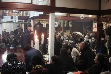 The spectators wait patiently while the candles are lit and the instrumentalists take their place on stage; once all is set, the Noh evening can begin for good