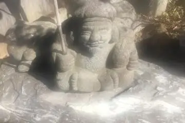 Statue of a man sitting while fishing