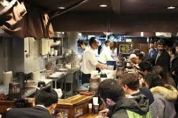 Row of diners in front of queuing customers.