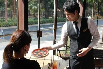 Pramusaji menyajikan pizza
