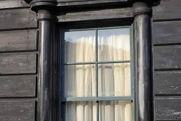 The windows upstairs and down have different pillars and pediments.