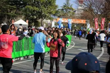 <p>Apr&egrave;s avoir elle-m&ecirc;me achev&eacute; l'&eacute;preuve, la championne olympique Naoko Takahashi se tient sur la ligne d'arriv&eacute;e pour f&eacute;liciter les coureurs d'une tape dans la main&nbsp;</p>