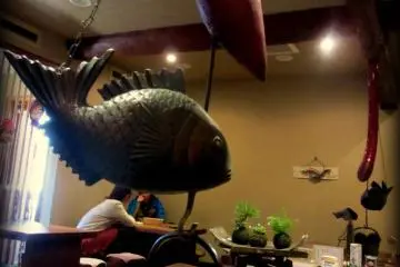 Kettles hang from the ceiling above each bench-style table