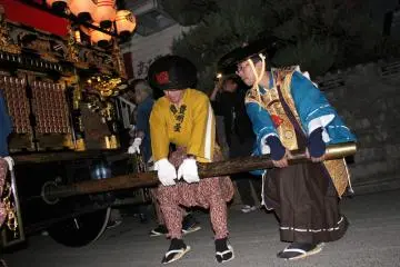 Groups of men work together to move & steer the floats through the streets.