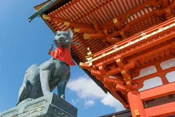 Une statue de Kitsune regardant les visiteurs du Fushimi Inari-taisha à Kyoto