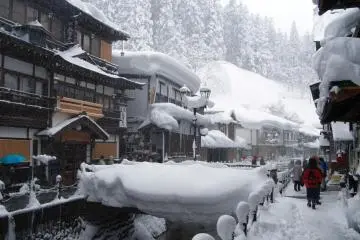 Some restaurants and souvenir shops at Ginzan Onsen invite visitors to step in and warm up their cold feet