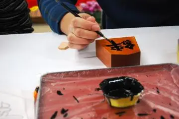 First you carefully paint the outline of the kanji character and then you fill it in with black paint - Tendo Town, home of Japanese chess