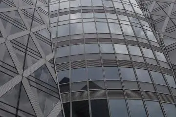 The windows reflect the sky and other buildings