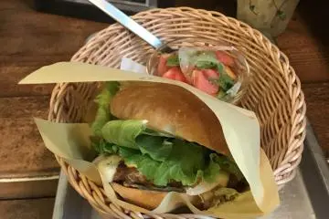Le cheeseburger accompagné d'une salade de tomates
