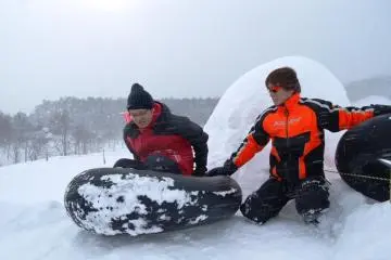 Riding a tire down the slope at Dondendaira Snow Park