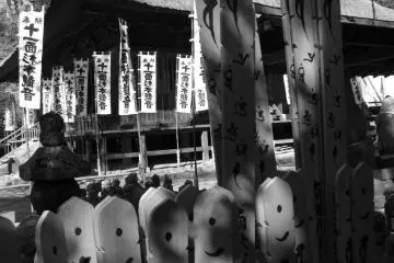 A collection of Buddhist statues, with the temple behind them