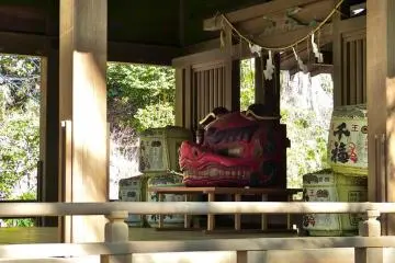 Red wooden statue of a lion's head; this is a talisman against evil spirit