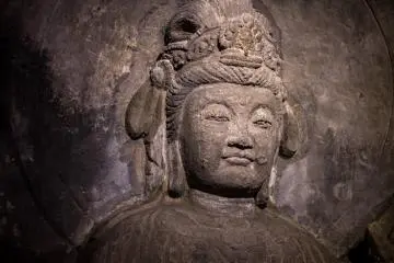 Statues are chiseled from the cave walls in the temple's Benten-kutsu Cave