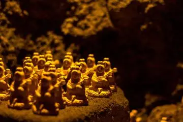 Visitors leave behind prayers and wishes in the form of these tiny statues within the dark Benten-kutsu Cave