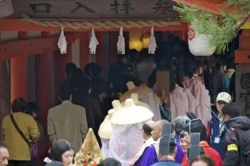 Paraders line up alongside regular visitors to enter Itsukushima Shrine.