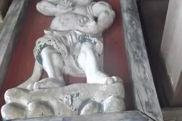 A wooden carving at the entrance to a shrine