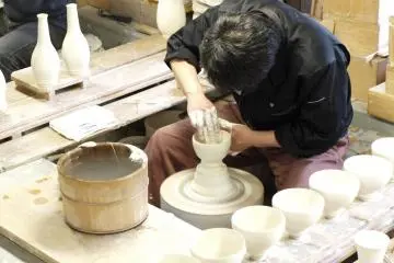 <p>A potter at work, shaping the vase</p>