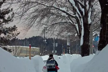 Winter: Kaneyama often receives over two metres of snow, but everyday life carries on as usual. Here, a junior high school student walks home along a path cut through the snow.