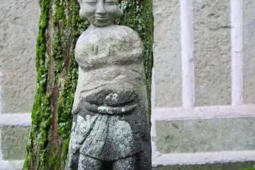 Statue, tree, house - this shrine is tucked in amongst a lot of houses