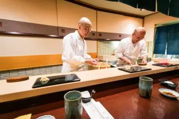 Jiro and his son Yoshikazu preparing sushi (Photo: <a href="https://www.flickr.com/photos/cityfoodsters/11557102206/in/album-72157639025344706/" target="_blank" rel="noreferrer noopener nofollow">City Foodsters (CC BY 2.0)</a>)