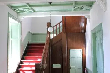 The staircase has those red carpets that they had in the olden days