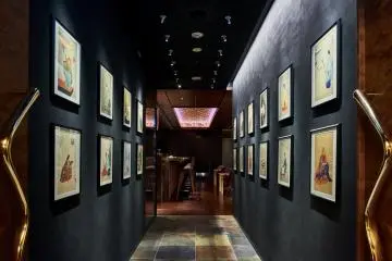 The entrance is lined with paintings, leading into the main lounge area