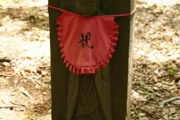 A red scarf adorns a small statue