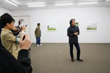 Tadashi Ono explaining the photos of his 'Coastal Motifs' exhibition