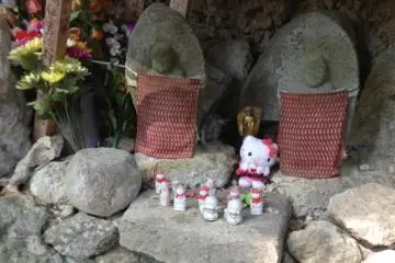 Offerings are found next to Buddhist statues. More modern offerings of toys or candy can be seen next to Japanese coins.