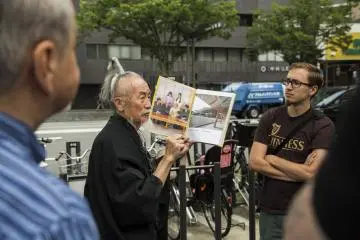 Okada menunjukkan kepada anggota tur koleksi fotonya dari tur sebelumnya