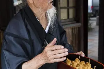 Okada mampir ke toko yang telah menjual inari selama lebih dari 50 tahun
