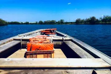 The wooden ferry is powered by a rudder and occasionally the outboard motor when the current is strong