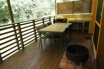 The covered back deck is ready for grilling and relaxing by the fire