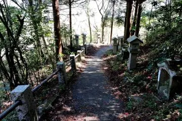 The entire path up to the cave is bordered with many stone lanterns and small statues